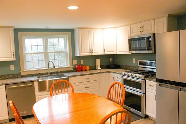 a kitchen with stainless steel appliances granite countertop a stove a sink a microwave and a refrigerator