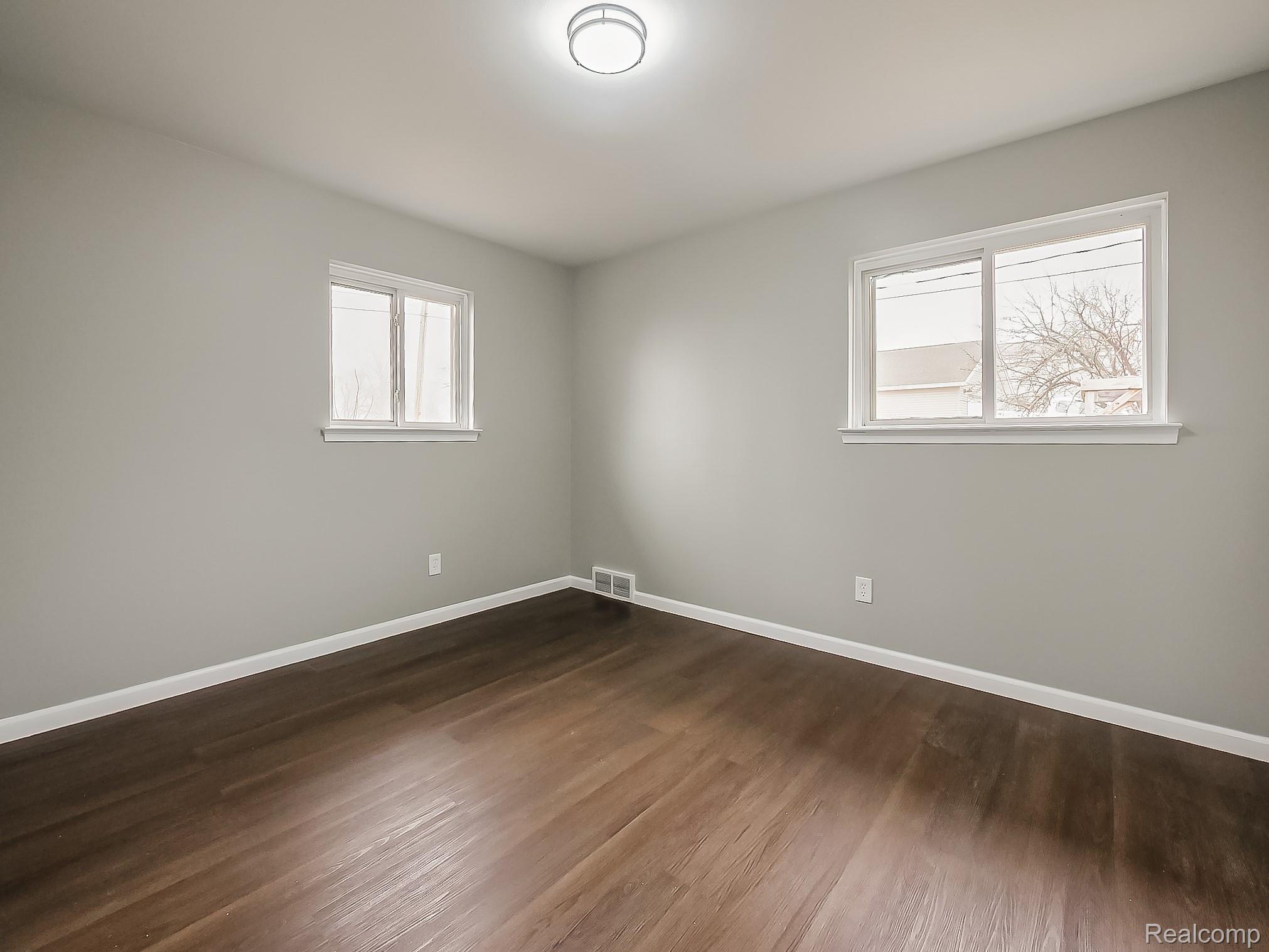 11780 Haggerty Road Belleville, MI 48111 - Photo 21 of 41 Empty room with baseboards and dark wood-style flooring