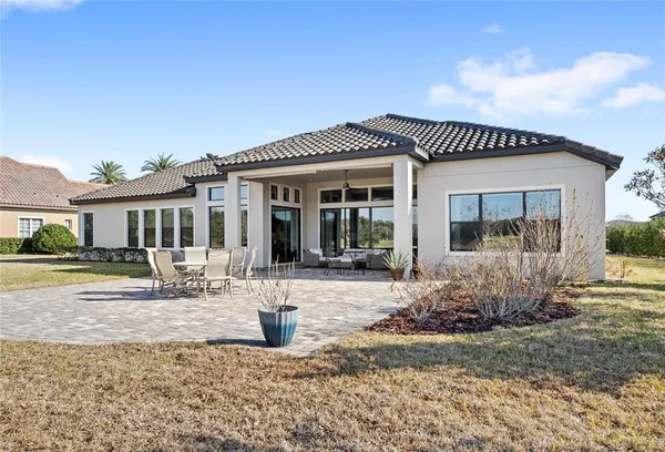 a view of a white house with a big yard and large trees
