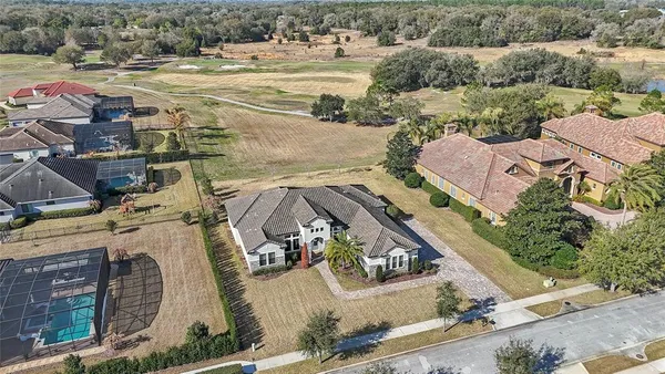 an aerial view of a house with a yard and large trees