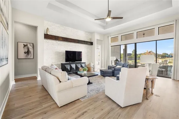 a living room with furniture wooden floor and a large window