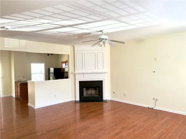 a view of a livingroom with wooden floor and a fireplace