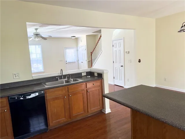 a kitchen with granite countertop a sink cabinets and wooden floor