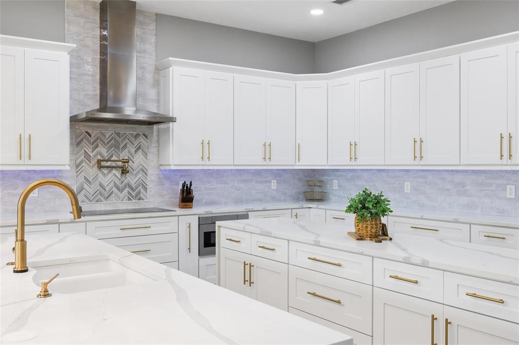 9810 Compass Point Way Tampa, FL 33615 - Photo 16 of 81 a kitchen with white cabinets and a stove
