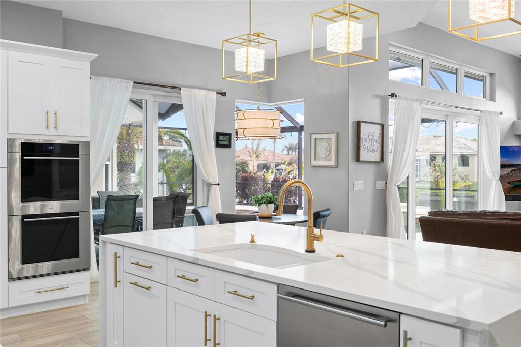 9810 Compass Point Way Tampa, FL 33615 - Photo 17 of 81 a kitchen with a sink dishwasher a stove and a dining table with wooden floor