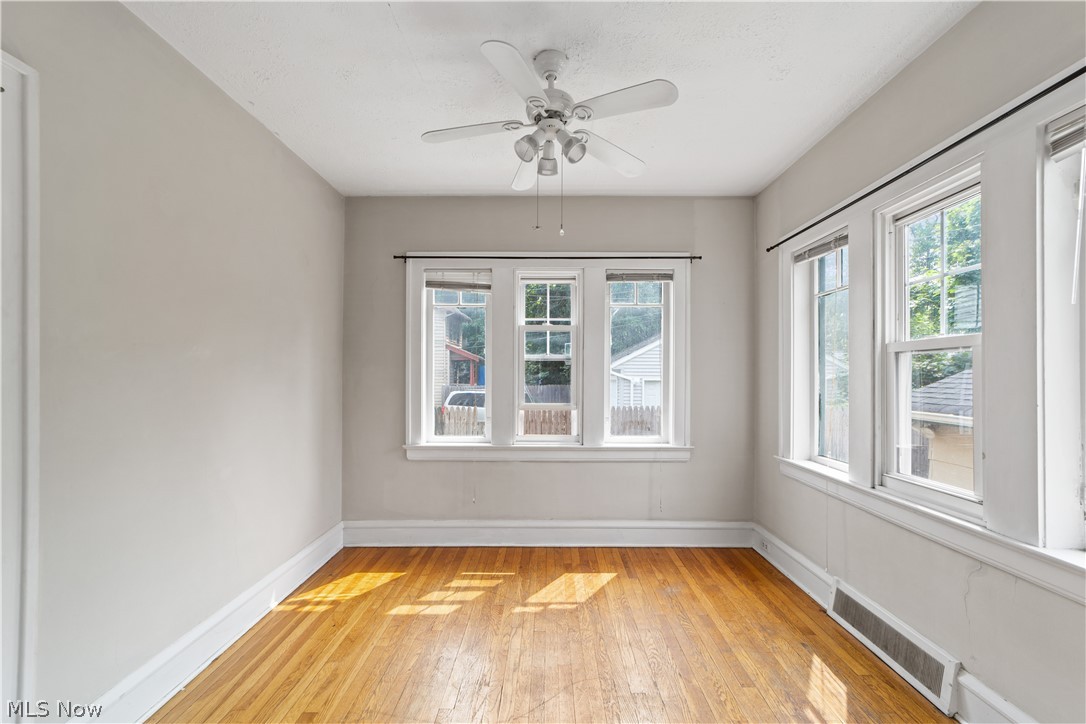 3076 Yorkshire Road Cleveland, OH 44118 - Photo 27 of 47 Empty room with ceiling fan, light hardwood / wood-style flooring, and a wealth of natural light