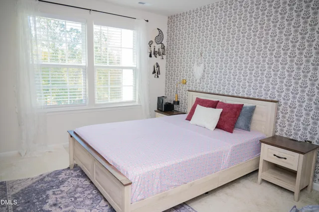 a bed sitting in a bedroom next to a window