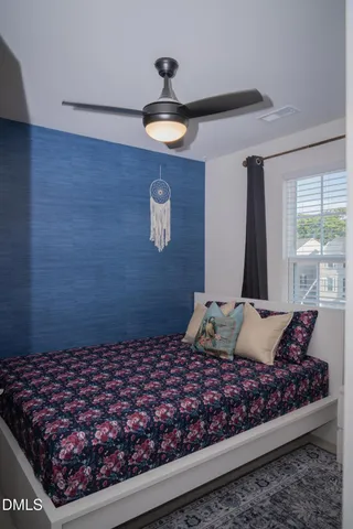 a bed sitting in a bedroom next to a window with a dresser