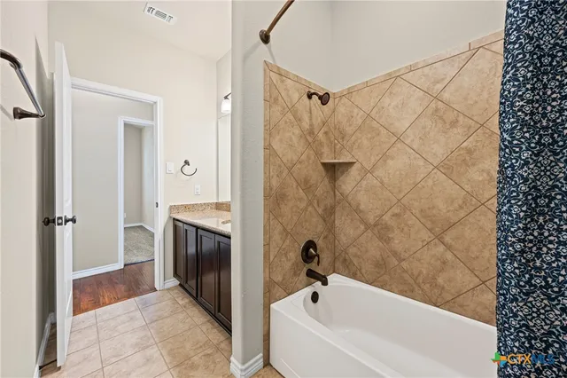 an empty room with wooden floor chandelier and windows