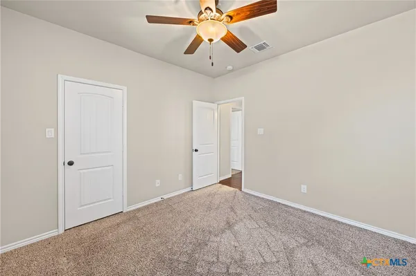 an empty room with chandelier fan