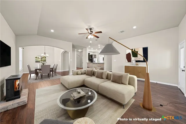 a living room with furniture a flat screen tv and a fireplace