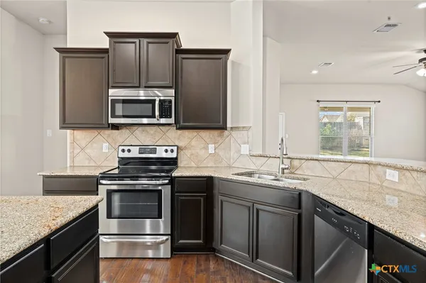 a kitchen with granite countertop stainless steel appliances and sink