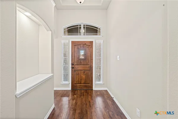 a walk in closet with wooden floor