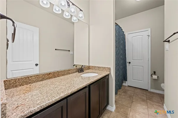 a bathroom with a granite countertop sink and a mirror