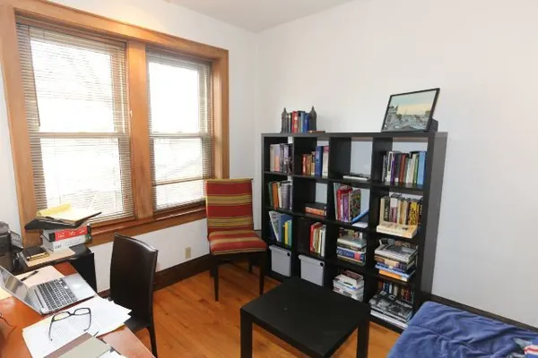 a view of a workspace with furniture and a book shelf