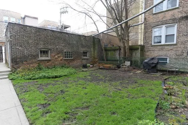 a backyard of a house with table and chairs