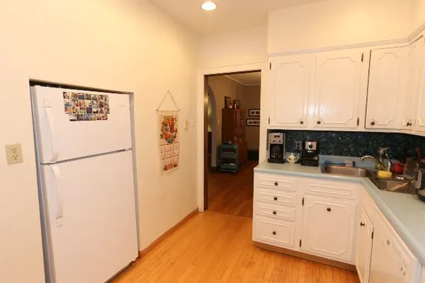 a kitchen with appliances a refrigerator and cabinets
