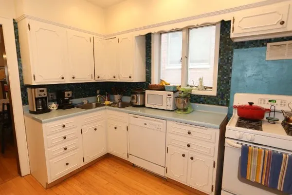 a kitchen with stainless steel appliances white cabinets and a window