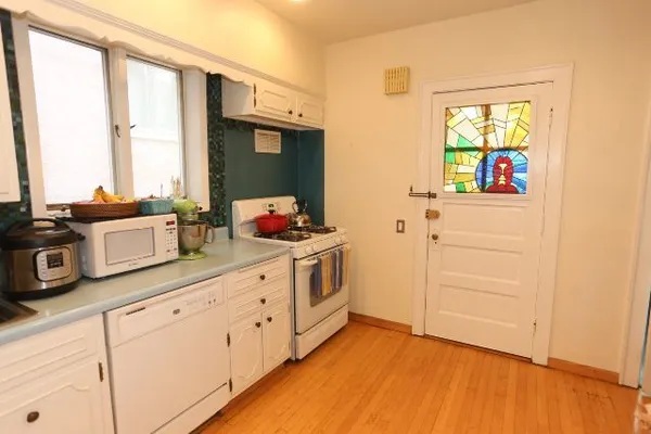 a kitchen with stainless steel appliances white cabinets and a window