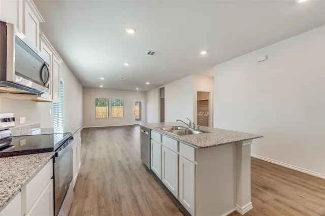 a kitchen with sink stove and refrigerator