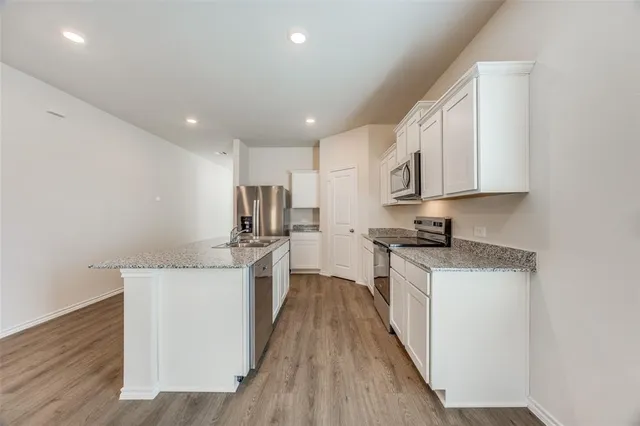 a view of a kitchen with a sink and a refrigerator