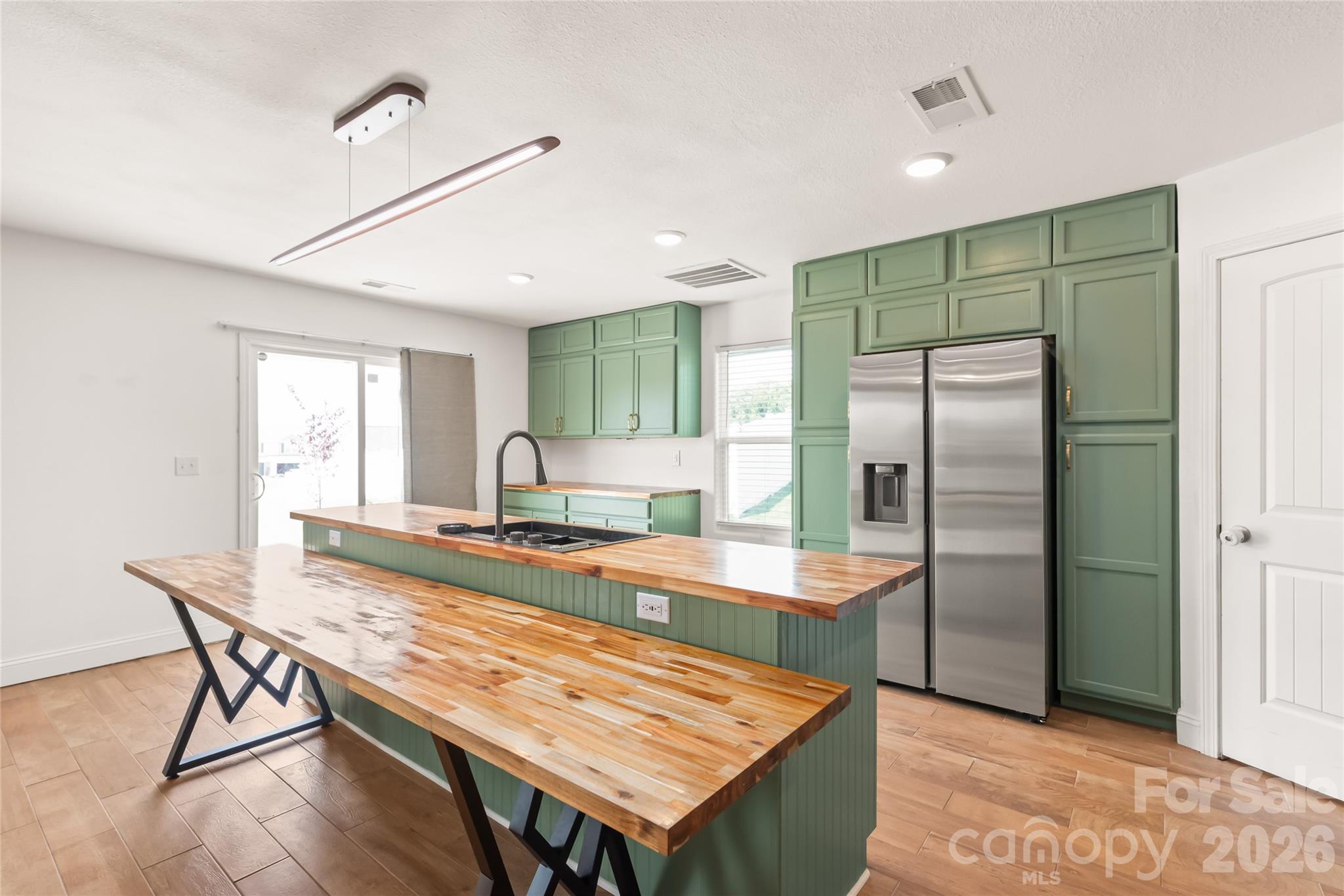 1232 Phifer Road Kings Mountain, NC 28086 - Photo 11 of 36 a kitchen with kitchen island a wooden floor and a refrigerator