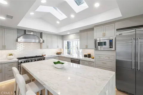 a large kitchen with granite countertop a large counter top and living room