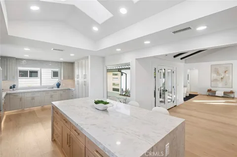 a kitchen with kitchen island a counter top space a sink stainless steel appliances and cabinets