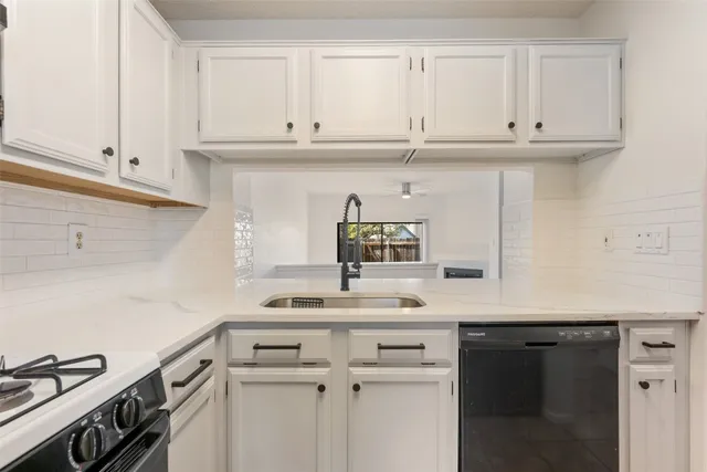 a kitchen with white cabinets and a sink