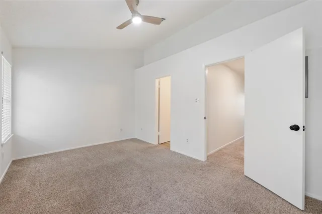an empty room with closet and windows