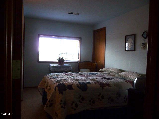 421 Blaine Road Granger, WA 98932 - Photo 14 of 23 a bed sitting in a bedroom next to a window