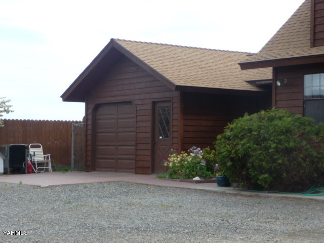 421 Blaine Road Granger, WA 98932 - Photo 19 of 23 a backyard of a house with wooden fence and a large tree