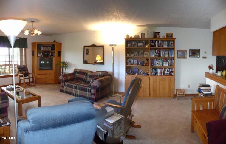 421 Blaine Road Granger, WA 98932 - Photo 5 of 23 a living room with furniture a flat screen tv and gym equipment