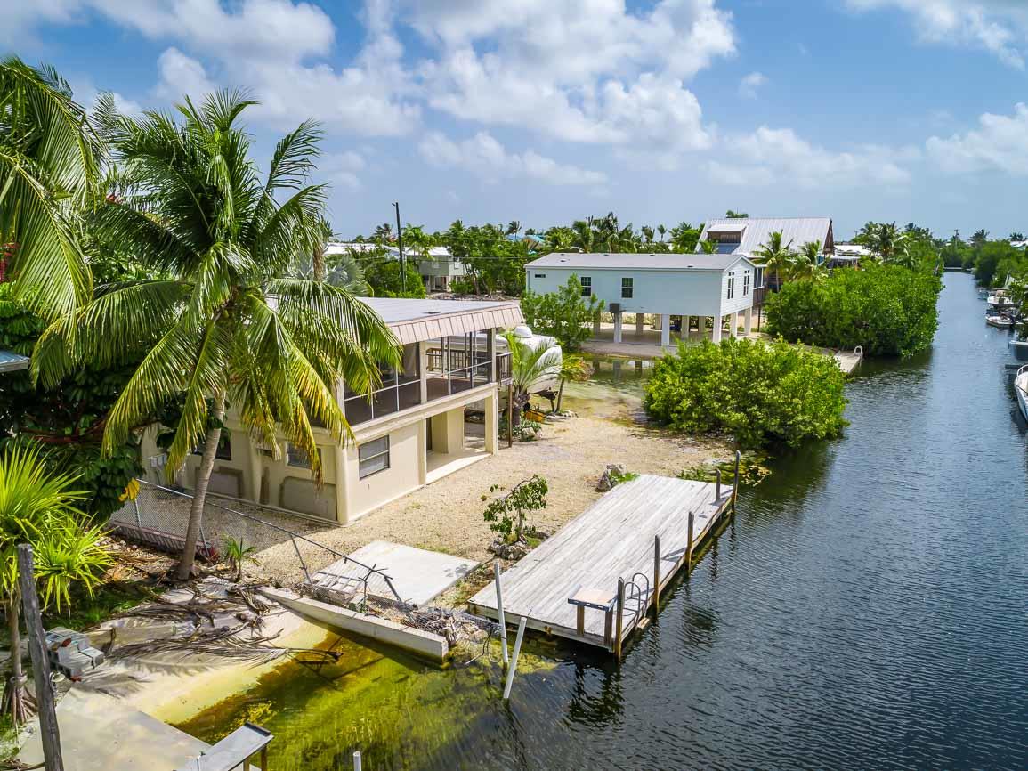 27346 Martinique Lane Summerland Key, FL 33042 - Photo 24 of 33 a view of a patio with table and chairs potted plants and large tree