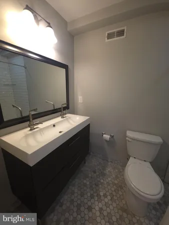 a bathroom with a sink toilet and mirror