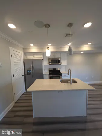a large kitchen with kitchen island a sink stainless steel appliances and cabinets