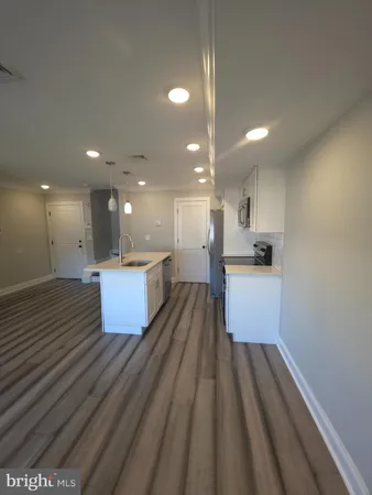 a large kitchen with kitchen island a sink stainless steel appliances and cabinets