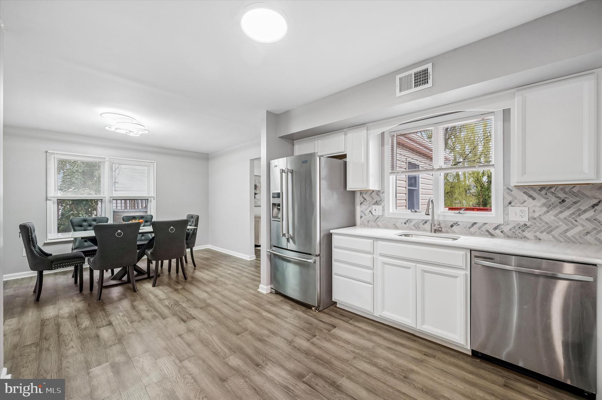 22 East Belair Road Ridley Park, PA 19078 - Photo 13 of 36 a kitchen with stainless steel appliances granite countertop a stove top oven a sink dishwasher a dining table and chairs with wooden floor