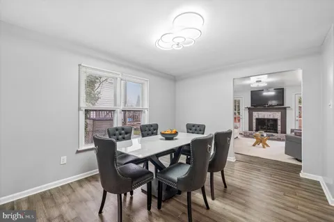 a kitchen with stainless steel appliances granite countertop a stove top oven a sink dishwasher a dining table and chairs with wooden floor