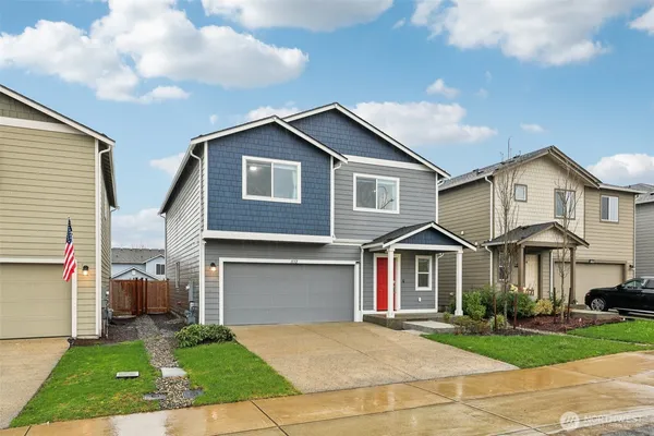 a front view of a house with a yard and garage