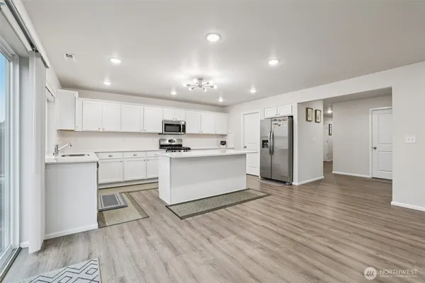 a kitchen with stainless steel appliances sink stove microwave and cabinets