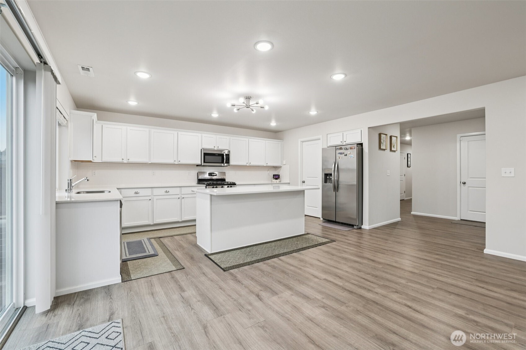1132 15th Avenue Sultan, WA 98294 - Photo 9 of 26 a kitchen with white cabinets and stainless steel appliances