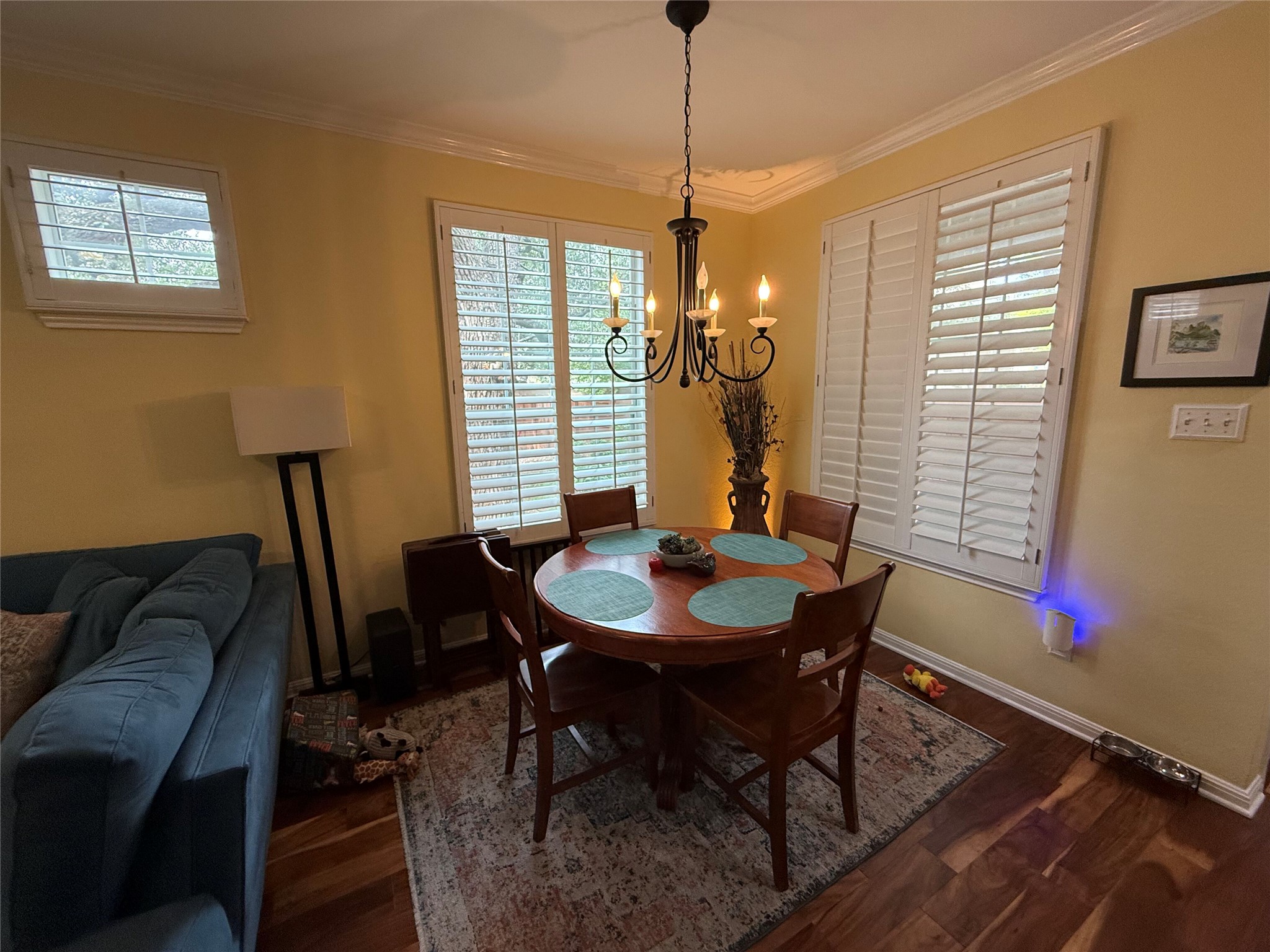 11000 Anderson Mill Road, Unit 93 Austin, TX 78750 - Photo 7 of 27 Elegant crown molding complements this inviting dining area with natural wood floors and warm lighting.