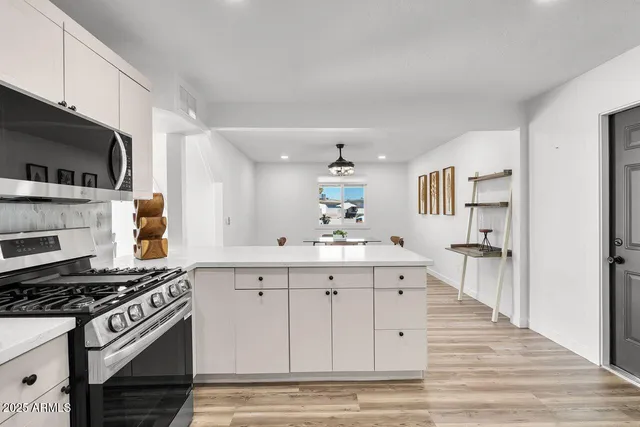 an empty room with wooden floor ceiling fan and windows