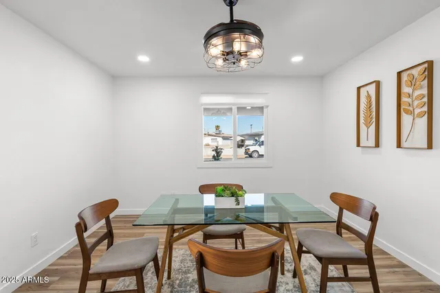a view of a livingroom with a chandelier fan and wooden floor