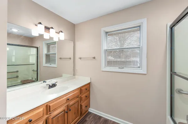 a bathroom with a sink tub and a mirror