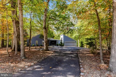 a view of a old house next to a yard with large trees