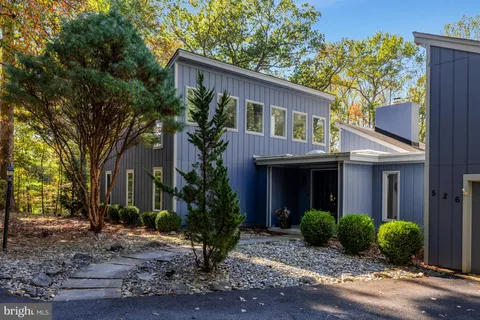 a front view of house with yard and trees around