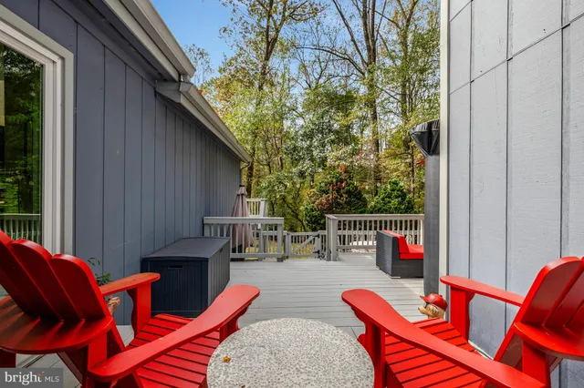 a view of a house with wooden deck and a tree