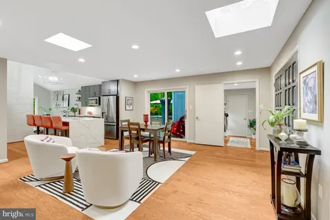a living room with furniture a dining table and kitchen view